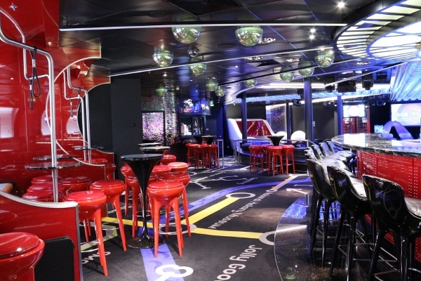 interior of a nightclub with bright red stools and carpeting that is a London Tube map