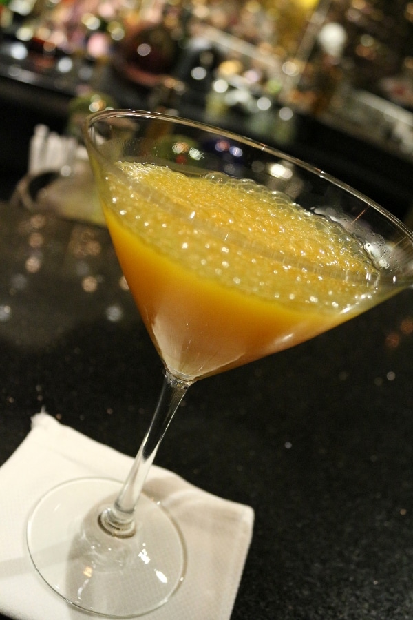 a bubbly orange drink in a cocktail glass