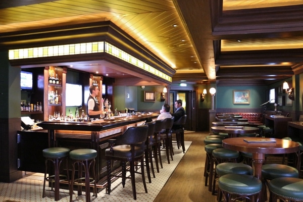 interior of an Irish pub with dark green and wood decor and a long bar