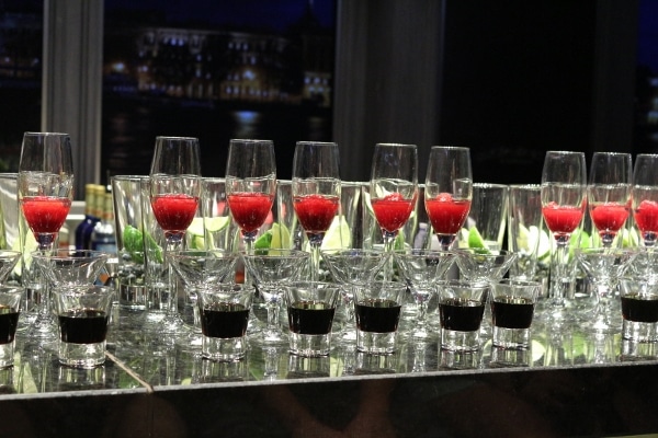 a closeup of glasses of drinks lined up on a bar