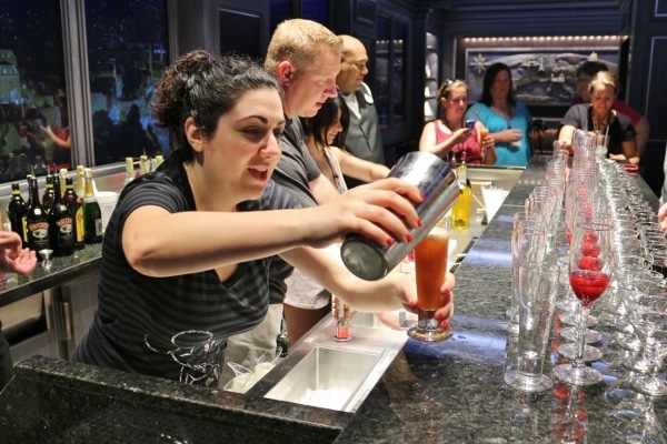 a closeup of a woman pouring a drink behind a bar