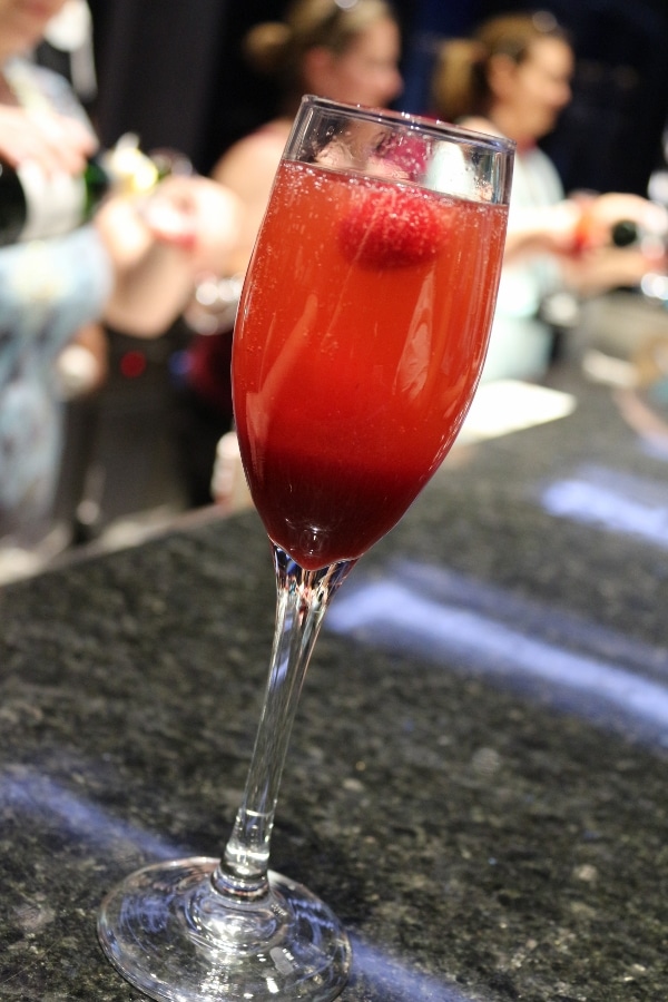 A close up of a fluted glass filled with a red drink