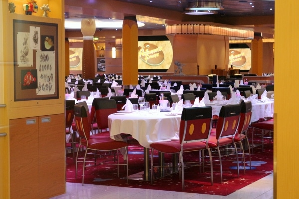 interior of a cruise ship restaurant with red chairs that look like Mickey Mouse\'s clothes