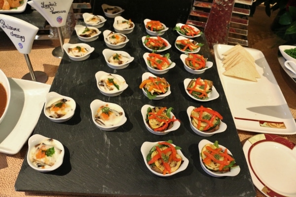 small white dishes of food on a black surface
