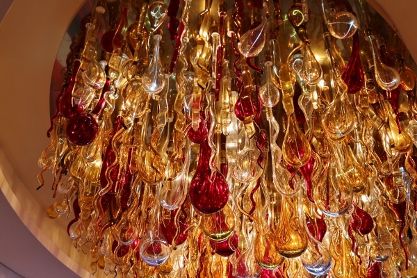 A closeup of red and yellow glass decorations hanging from a ceiling