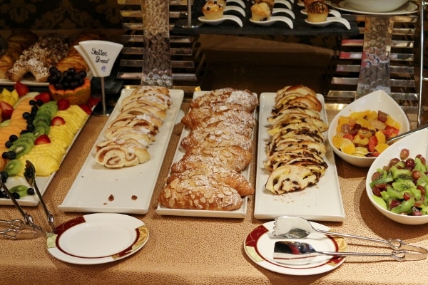 a closeup of various baked items and fruits on a buffet