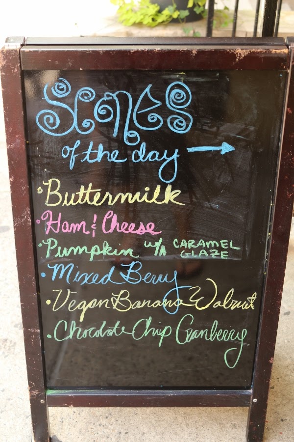 A blackboard sign that says Scones of the Day with a list of flavors