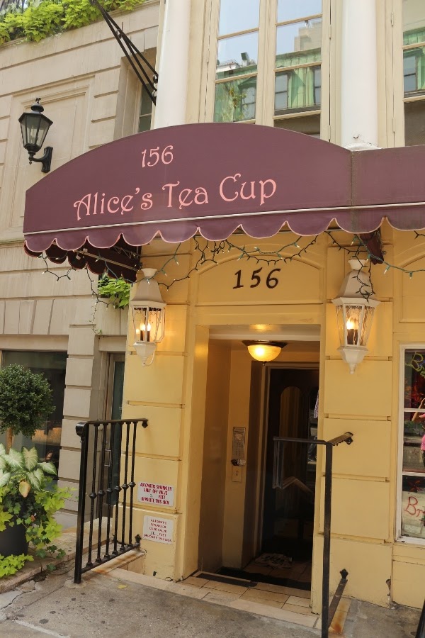 A sign on the side of a building that says Alice\'s Tea Cup