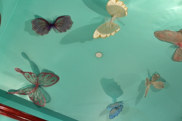 butterfly wing decorations on a turquoise ceiling