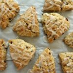 overhead view of triangular scones with glaze drizzled on top on a baking sheet