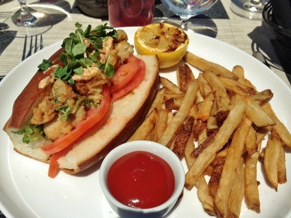 a clam po boy sandwich on a hot dog bun served with fries and ketchup