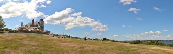 an inn on the left with a large green lawn leading to the oceanfront