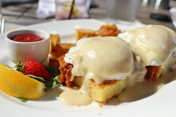 a closeup of Eggs Benedict on square pieces of cornbread with pulled pork