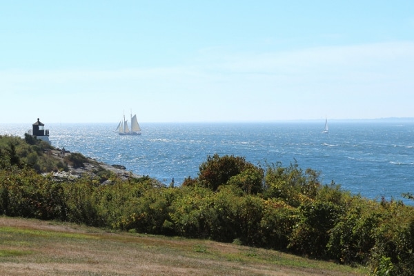 a view of a lighthouse and a sailboat in the distance