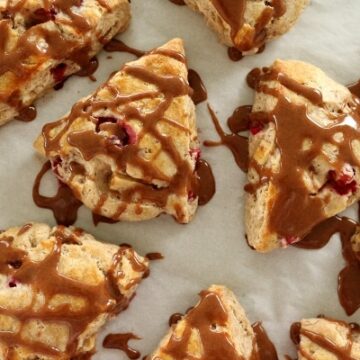 overhead view of triangular scones on a parchment lined baking sheet topped with cinnamon glaze