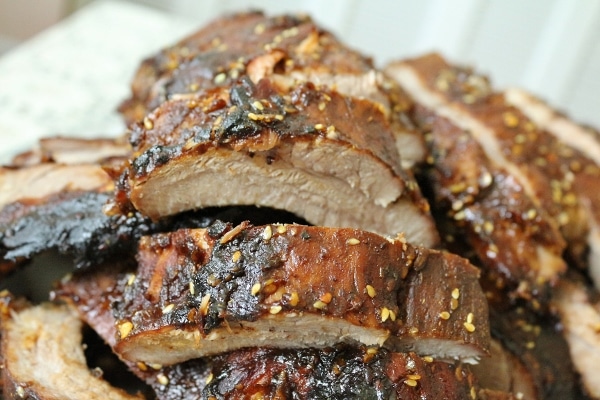 a closeup of a pile of baby back ribs with sesame hoisin sauce