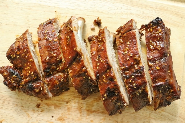 overhead view of sliced baby back ribs with hoisin sesame sauce on a wooden board