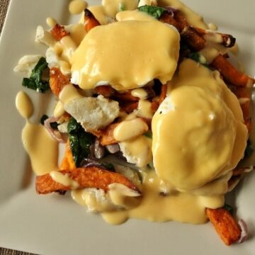 overhead view of a square plate topped with fish hash, eggs, and Hollandaise sauce