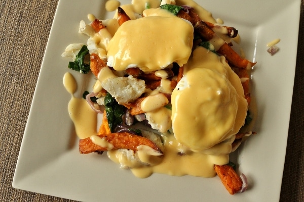 overhead view of a square plate topped with fish hash, eggs, and Hollandaise sauce