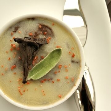 overhead closeup of a ramekin topped with cold butter layer, trumpet mushroom, and sage