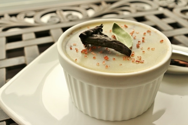 side view of a white ramekin filled with pate, red salt, and a mushroom