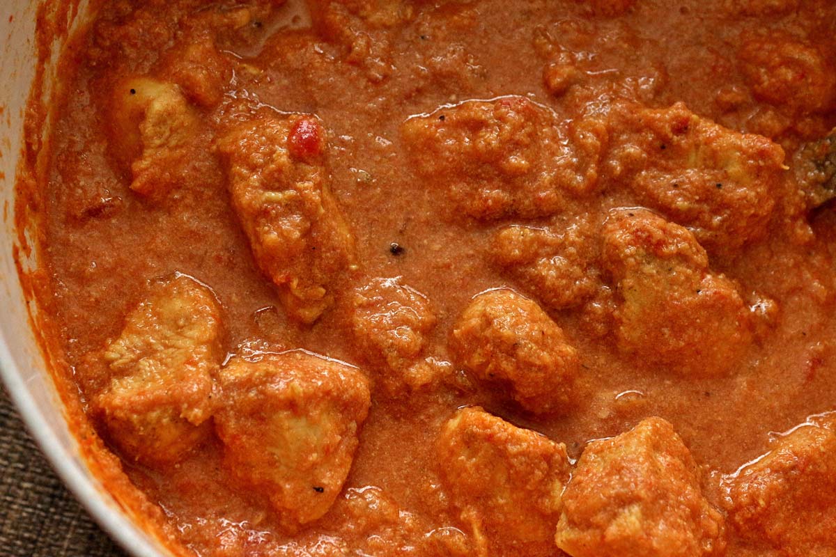 A pot of Indian curry with chicken and a creamy tomato sauce.