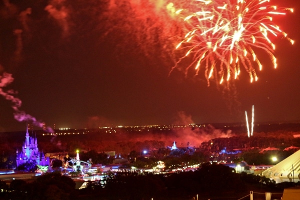 A group of fireworks in the sky behind the Magic Kingdom theme park