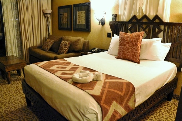 A hotel room with a large bed and sitting area