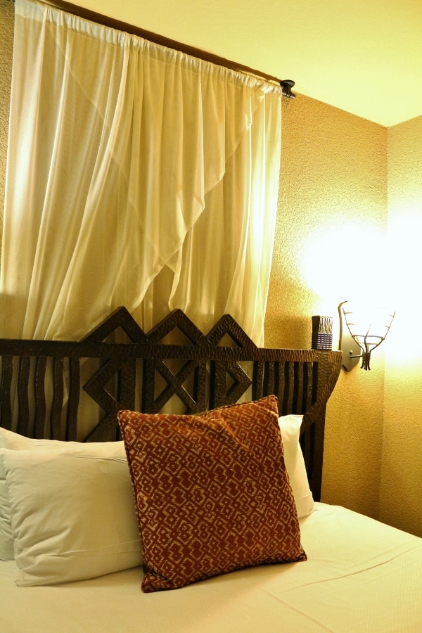 an ornate wooden headboard over a hotel bed