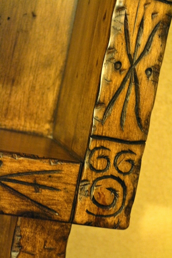 a closeup of a Hidden Mickey carved on a wood dresser