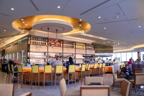 a wide view of a modern looking bar in a restaurant with yellow bar stools