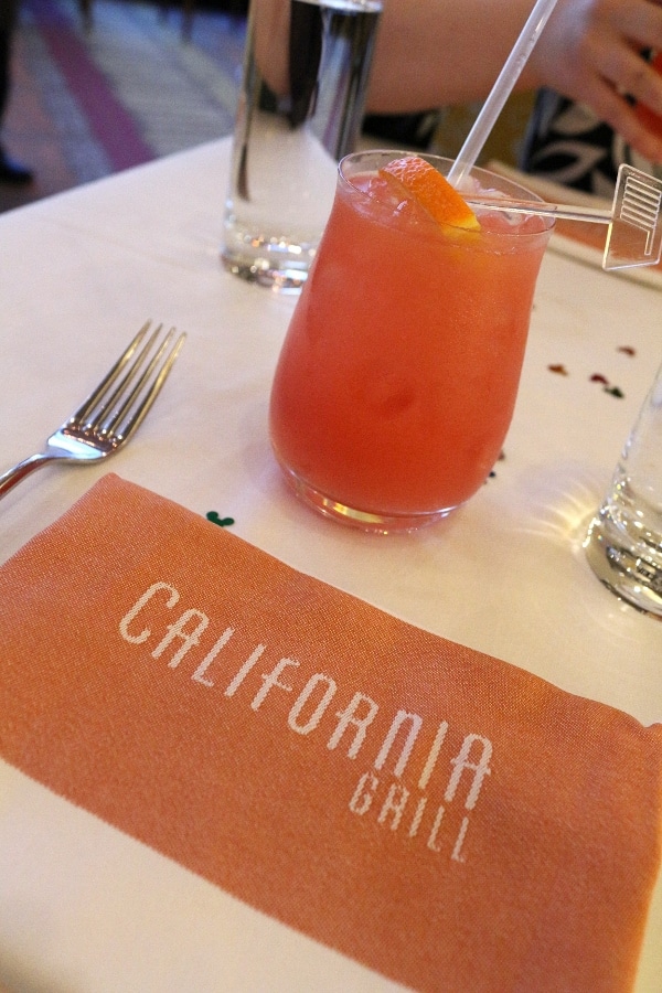 a colorful cocktail on a table next to a cloth napkin that says California Grill