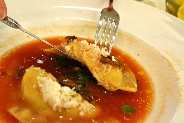 peeking into the cross section of a halved ravioli to see the cheese filling