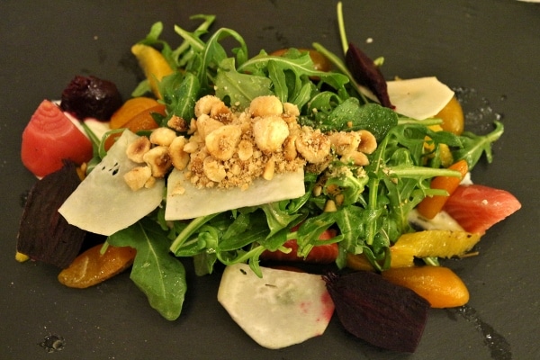 A plate of salad with beets and nuts