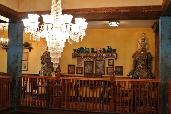 a crystal chandelier hanging in front of various Asian decorations against a wall