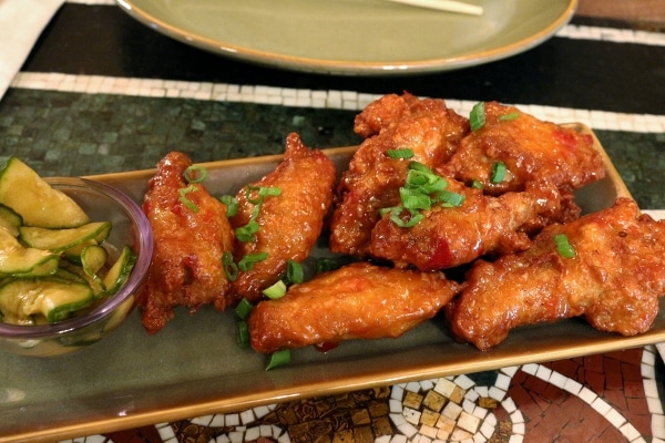 A plate of fried chicken wings garnished with scallions