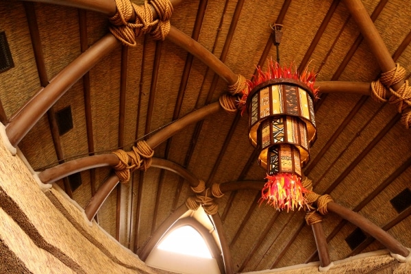 view looking up at the thatched ceiling and colorful lights inside the Animal Kingdom Villas lobby