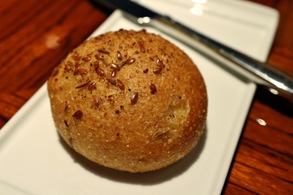 A seeded roll on a small white plate