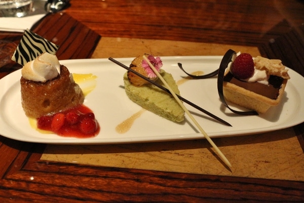a trio of desserts on a rectangular white plate