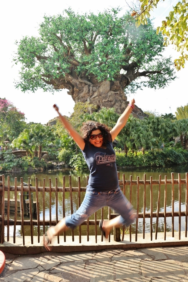 A woman jumping in front of the Tree of Life in Disney\'s Animal Kingdom park