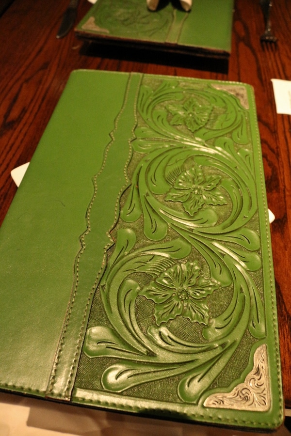 a green menu cover with a floral design