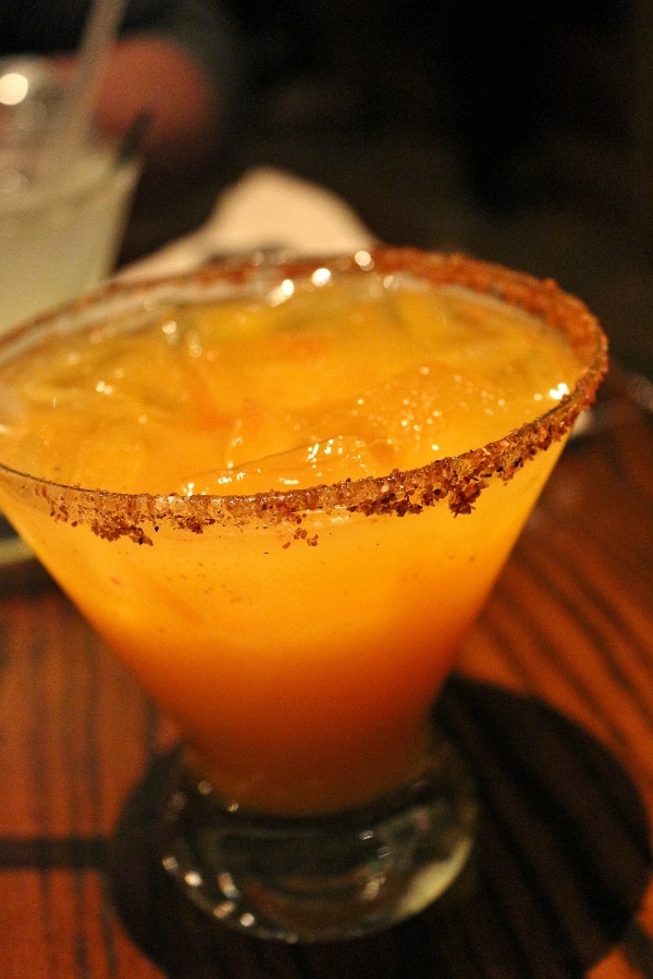 an orange-colored margarita in a glass