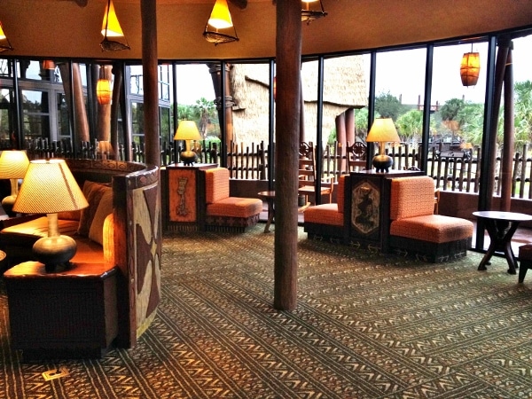 a lounge area with orange cushioned chairs and warm lights