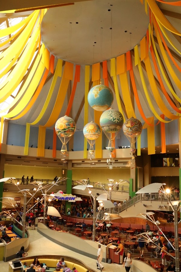 interior of The Land Pavilion with fake hot air balloons and warm colored streamers