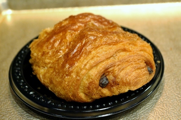 A closeup of a pain au chocolat chocolate croissant on a plate