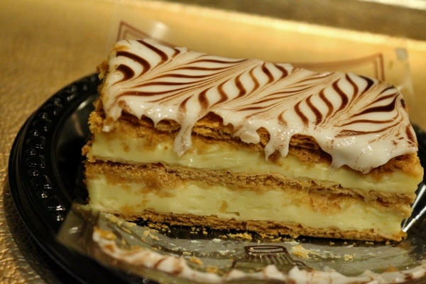 a closeup of a napoleon pastry with layers of cream and flaky dough