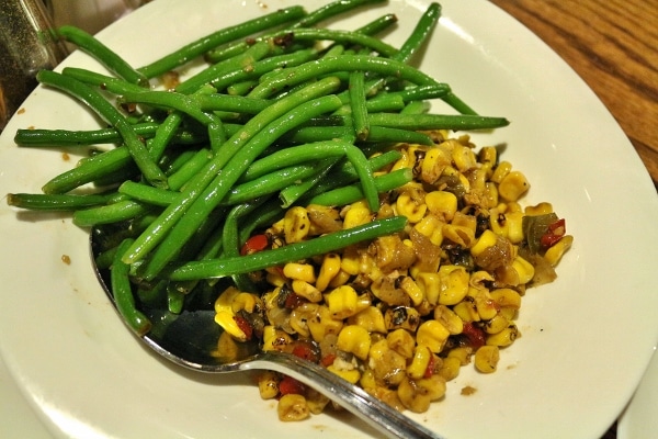 a plate of sauteed green beans and corn on the side