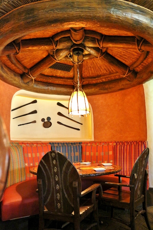 a colorful table in a restaurant with a Hidden Mickey hanging on the wall