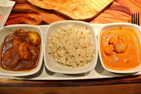 overhead view of two types of curry and rice in small white bowls