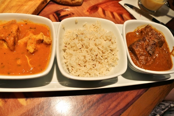 overhead view of two types of curry and rice in small white bowls